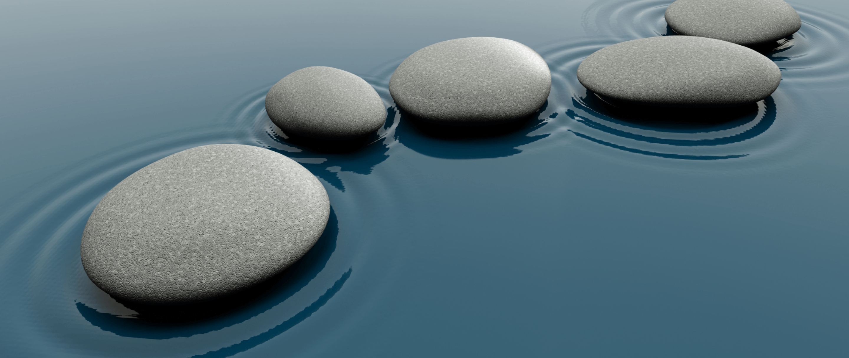 A photo of five smooth stones on calm water, creating concentric ripples. Illustration symbolizing balance and serenity.