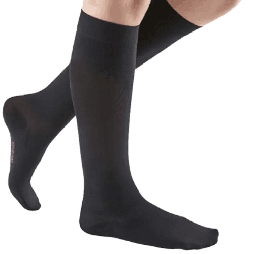 Photo of a person wearing black knee-high compression socks, designed for support and improved circulation.