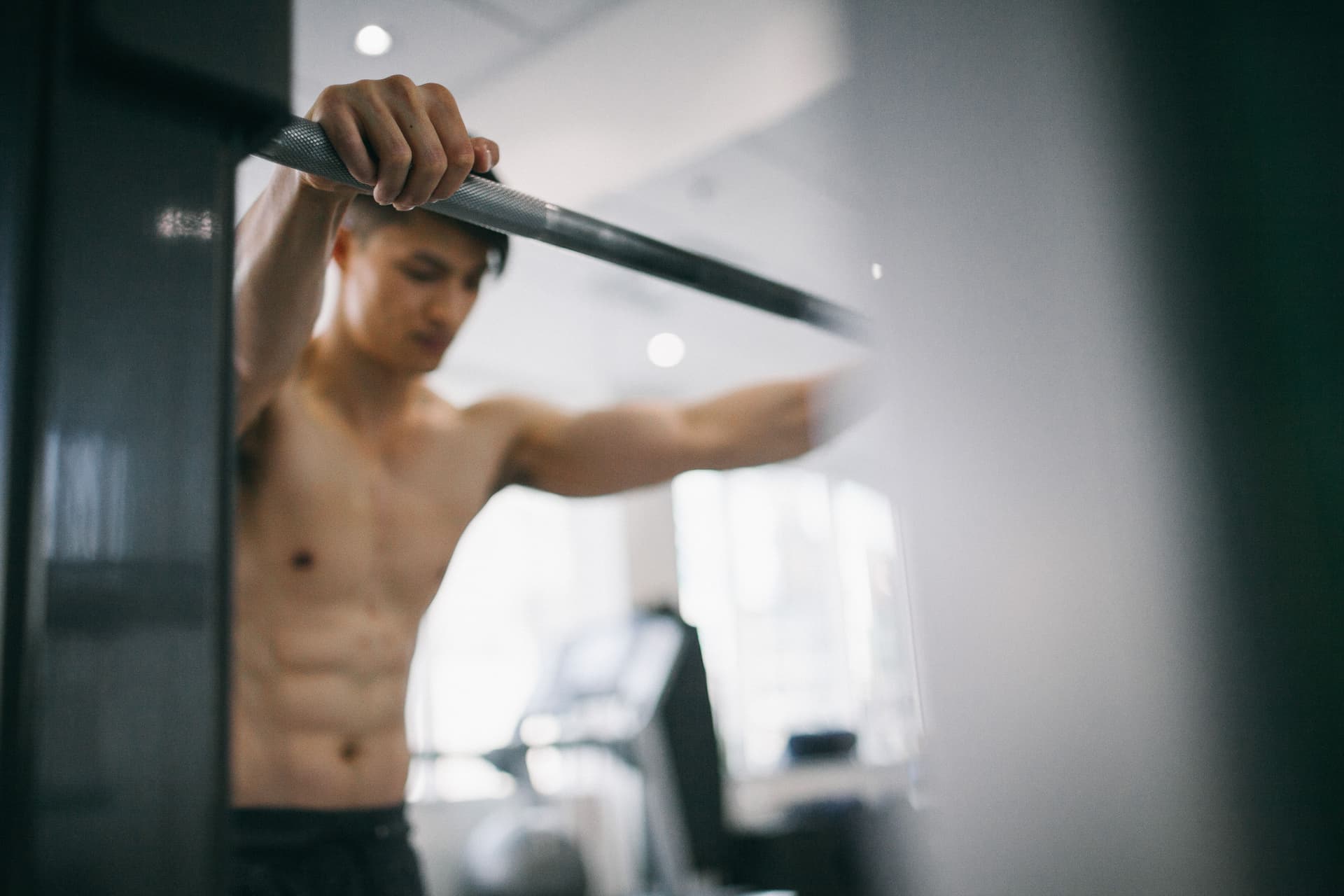 Man gripping barbell, shot with soft focus in gym setting